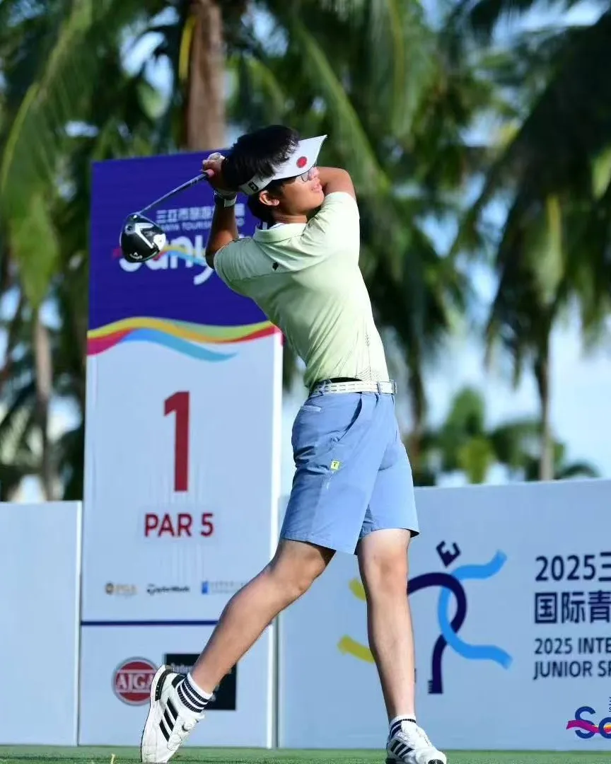 Louis Jia finishing a drive on the first tee, a par 5